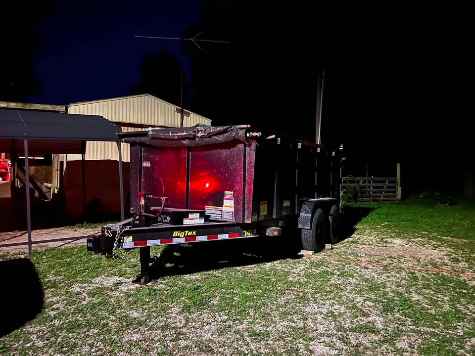TX2 black 14-yard dump trailer staged for an evening pickup